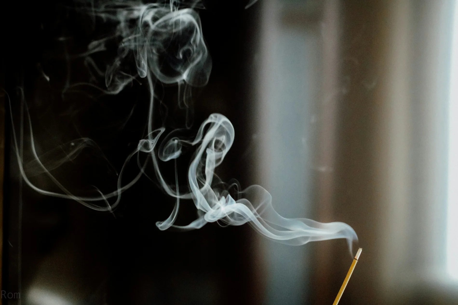 Delicate white smoke curling across a bright white background